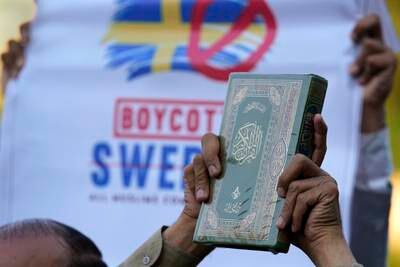 A man holds a copy of Islam's holy book the Quran as he with others take part in a rally, in Islamabad, Pakistan, Monday, July 2, 2023, against the desecration of Islam's holy book Quran that took place in Sweden. AP