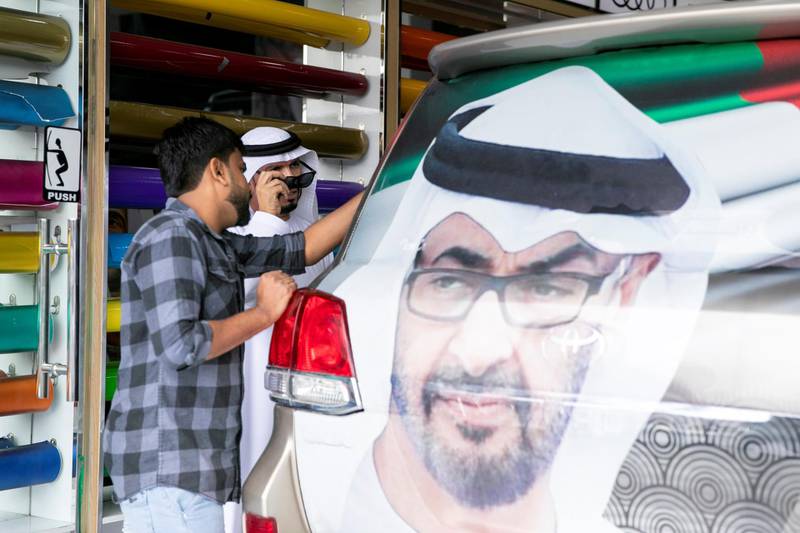 ABU DHABI, UNITED ARAB EMIRATES - NOVEMBER 27, 2018. Rashid Al Muhairbi, who's birthday falls on UAE National's day, decorates his car at Grand Plus Auto Accessories. Car accessory shops in Mussafah are keeping busy as motorists rush to dress up their vehicles ahead of the UAE's 47th National Day.(Photo by Reem Mohammed/The National)Reporter:  HANEEN DAJANISection:  NA