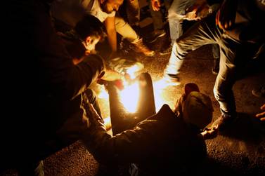 Protesters extinguishing a man who set himself on fire during a demonstration to protest sexual harassment and bullying and demanding rights, in front of the government house in downtown Beirut, Lebanon. AP