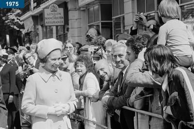 1975: The queen greets the public while visiting Greenwich, London.