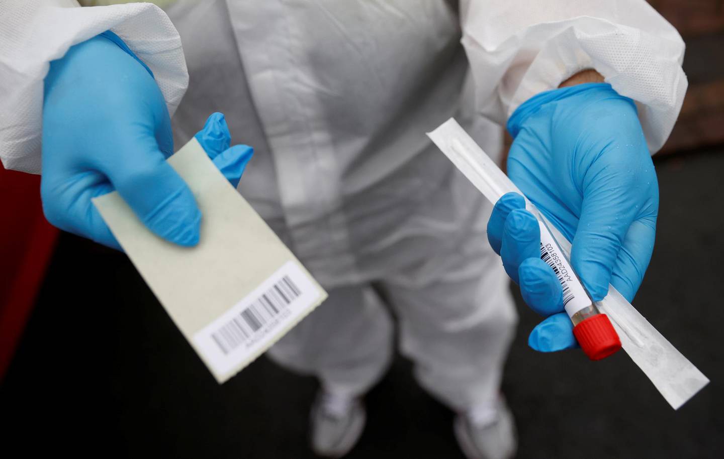 A member of the community swabbing team holds a testing kit before he carries out a doorstep COVID-19 testing following the outbreak of the coronavirus disease (COVID-19) in Chadderton, Britain, September 30, 2020. Picture taken September 30, 2020.  To match Special Report HEALTH-CORONAVIRUS/BRITAIN-NEWWAVE    REUTERS/Phil Noble