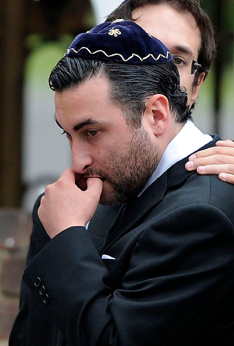 Alex Winehouse, brother of late British singer Amy Winehouse, is comforted by friends and relatives as he attends a cremation ceremony for his sister in north London, on July 26, 2011.  Amy Winehouse's family, friends and fans paid their last respects to the troubled British soul singer at her funeral on Tuesday, three days after the 27-year-old was found dead at her London home. AFP PHOTO / CARL COURT
 *** Local Caption ***  496623-01-08.jpg