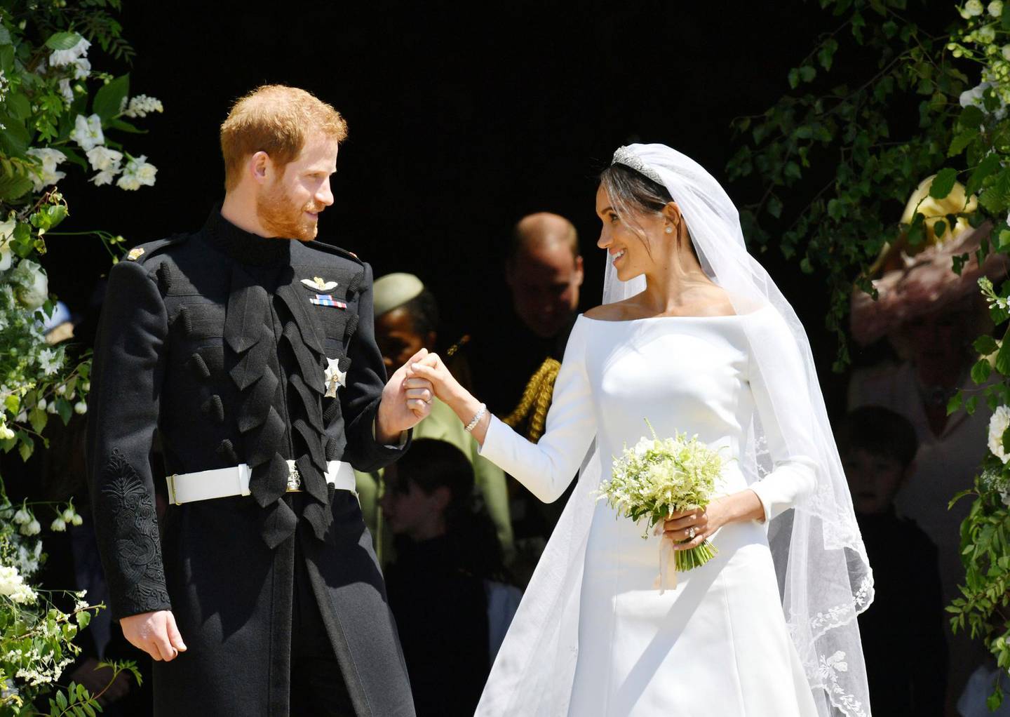 FILE - In this Saturday, May 19, 2018 file photo, Britain's Prince Harry and Meghan Markle stand on the steps of St. George's Chapel in Windsor Castle in Windsor, near London, England, after their wedding ceremony. The outfits Prince Harry and Meghan Markle wore at their wedding are to go on public display from Oct. 26, 2018 at the ceremony's venue, Windsor Castle. (Ben Birchhall/pool photo via AP, File)