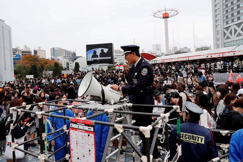 A security guard supervises fans of South Korean boy band BTS outside Tokyo Dome where the band's concert will be held in Tokyo, Japan. Kim Kyung-Hoon / Reuters