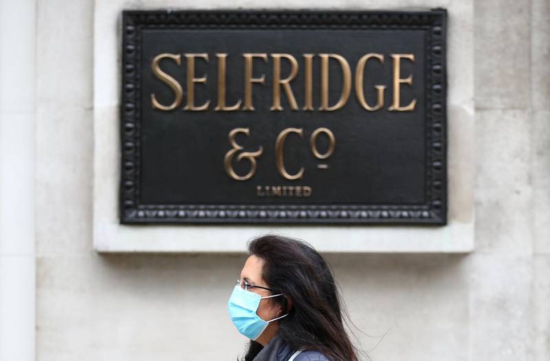 FILE PHOTO: A woman wearing a protective mask walks past a Selfridges store at Oxford Street, amid the coronavirus disease (COVID-19) outbreak, in London, Britain July 28, 2020. REUTERS/Hannah McKay/File Photo