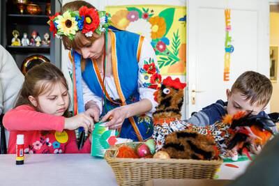 Vladimir and Avigeja Radionow with Kseniia Temcheniuk, who fled war-torn Ukraine, prepare an Easter basket at a cultural centre in Halle, Germany. Getty Images