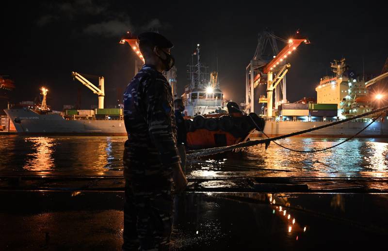 A Navy sailor stands guard as the KRI Gilimanuk (531) warship prepare to leave for a search and rescue operation for the Sriwijaya Air flight SJY182 from the Tanjung Priok port in Jakarta. AFP
