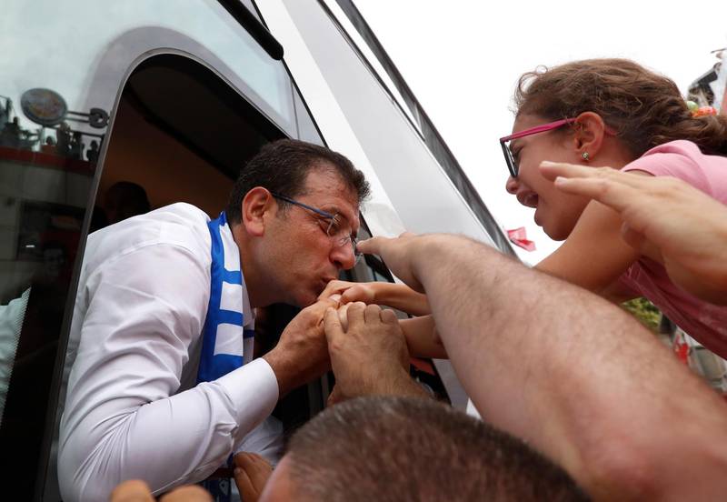 Ekrem Imamoglu, candidate of the secular opposition Republican People's Party, or CHP, reaches out from his campaign bus to to kiss a young supporter following a rally in Istanbul, Friday, June 21, 2019, ahead of June 23 re-run of Istanbul elections.The 49-year-old candidate won the March 31 local elections with a slim majority, but after weeks of recounting requested by the ruling party, Turkey's electoral authority annulled the result of the vote, revoked his mandate and ordered the new election.(AP Photo/Lefteris Pitarakis)