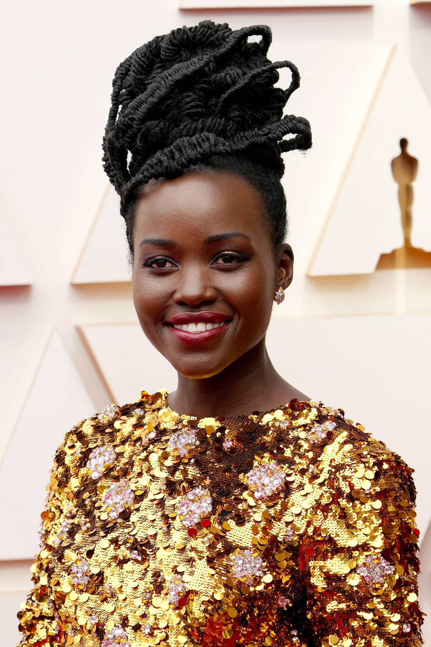 Lupita Nyong'o wore deep red lipstick to compliment her gold dress, at the 2022 Academy Awards. Getty Images 