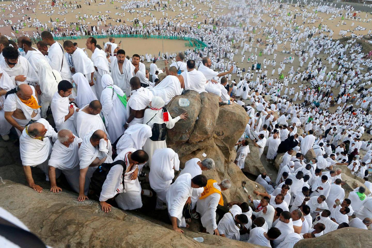 Muslim pilgrims make their way down on a rocky hill known as Mountain of Mercy, on the Plain of Arafat, during the annual hajj pilgrimage, near the holy city of Mecca, Saudi Arabia, Saturday, Aug. 10, 2019. More than 2 million pilgrims were gathered to perform initial rites of the hajj, an Islamic pilgrimage that takes the faithful along a path traversed by the Prophet Muhammad some 1,400 years ago. (AP Photo/Amr Nabil)
