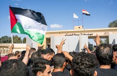 Volunteers from humanitarian aid organisations chant slogans during a protest at the Rafah border crossing, in Egypt, on Wednesday.  EPA
