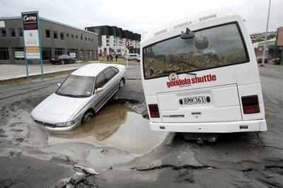 Vehicles trapped in a hole in the road on February 23, 2011, a day after a deadly 6.3 magnitude earthquake rocked the city of Christchurch. AFP