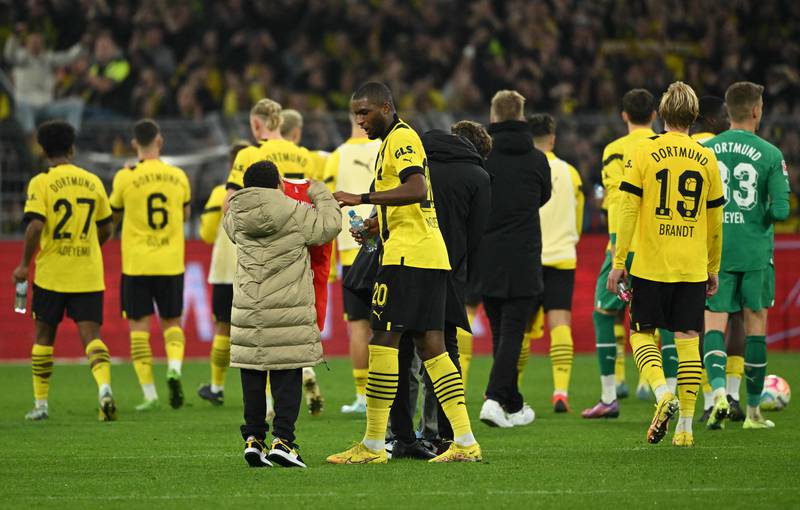 Anthony Modeste talks to his son on the pitch after Dortmund's Bundesliga draw with Bayern Munich. AFP
