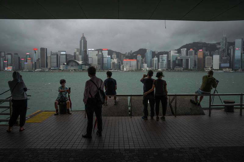 People take photos from Victoria Harbour as Typhoon Chaba passes Hong Kong. AFP