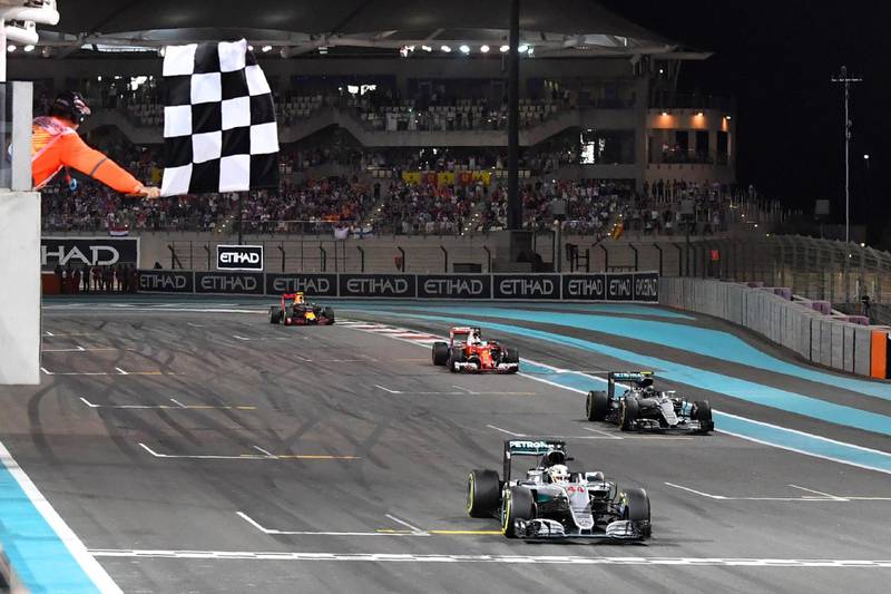 Mercedes AMG Petronas F1 Team's British driver Lewis Hamilton crosses the finish line at the end of the Abu Dhabi Formula One Grand Prix at the Yas Marina circuit on November 27, 2016. - Nico Rosberg won his maiden Formula One world title by securing second place behind his Mercedes arch-rival Lewis Hamilton in the Abu Dhabi Grand Prix. (Photo by Andrej ISAKOVIC / AFP)