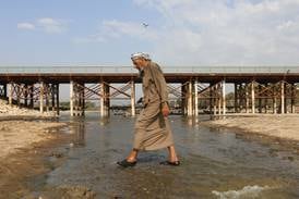A man crosses Iraq's Abu Lehya river, which has suffered from a drought-induced drop in water levels. Raising public awareness about resource constraints, and of the burdens that rapid population growth places on arable land and fresh water, is overdue. AFP