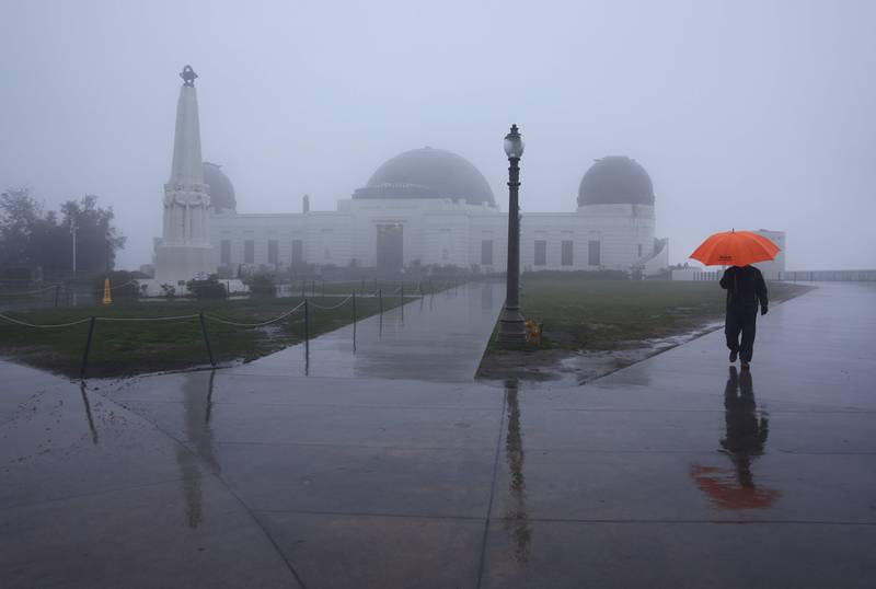 A person walks in the rain at Griffith Observatory in Los Angeles during the major storm. AFP