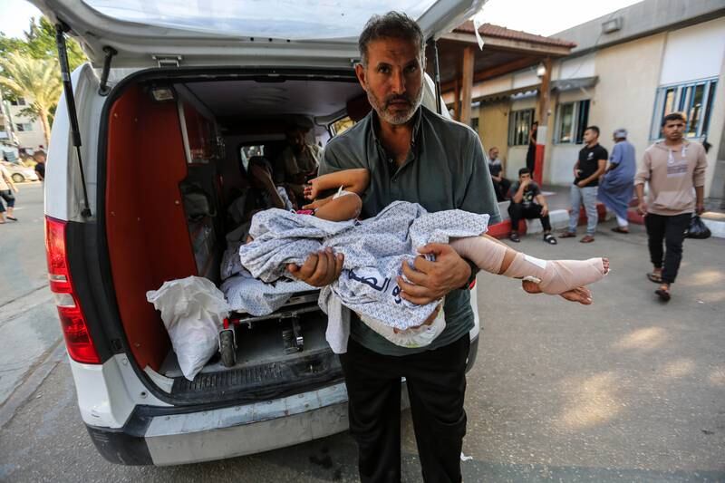 A wounded Palestinian child is carried into the Rafah crossing between Gaza and Egypt to receive treatment. Getty Images