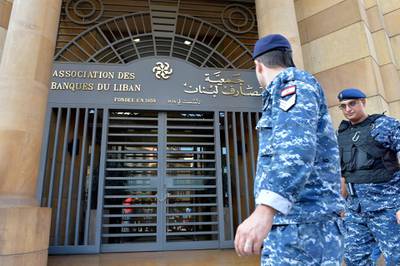 Lebanese policemen walk in front of the building of the Lebanese Association of Banks after anti-government protesters locked the main entrance by a chain and lock during ongoing protests against the banks' policies and the government in downtown Beirut, Lebanon.  EPA