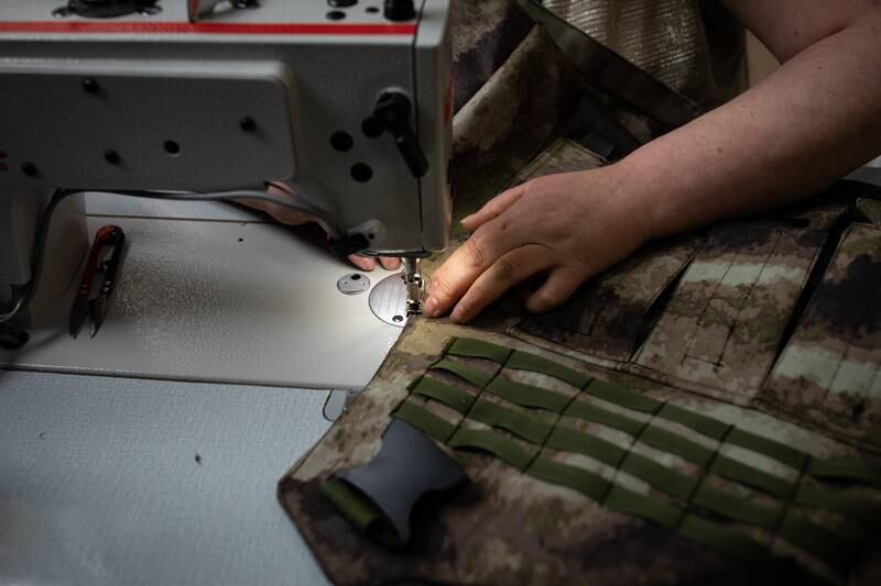 Seams are secured on a camouflage vest made to carry steel plates for those fighting for Ukraine against Russia.