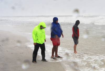 Freelance journalist, Trey Greenwood, Micah Hart and Alec Scholten are battered by the winds and rain from the outer bands of Hurricane Sally in Gulf Shores, Alabama. AFP