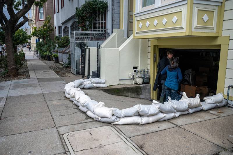 Residents pile protective sand bags around the entrance to their garage in the Mission District of San Francisco. Bloomberg