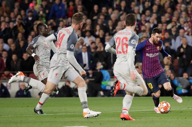 Barcelona's Lionel Messi, right, plays the ball past Liverpool's Andy Robertson, second right, Jordan Henderson, second left, and Sadio Mane. Emilio Morenatti / AP Photo