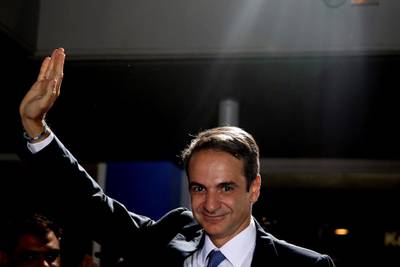 Greek opposition New Democracy conservative party leader Kyriakos Mitsotakis waves to his supporters after win in parliamentary elections at the New Democracy headquarters in Athens, on Sunday, July 7, 2019. Official results from nearly 60% of ballots counted showed the conservative New Democracy party of Kyriakos Mitsotakis winning comfortably with 39.7% compared to Tsipras' Syriza party with 31.5%. (AP Photo/Petros Giannakouris)