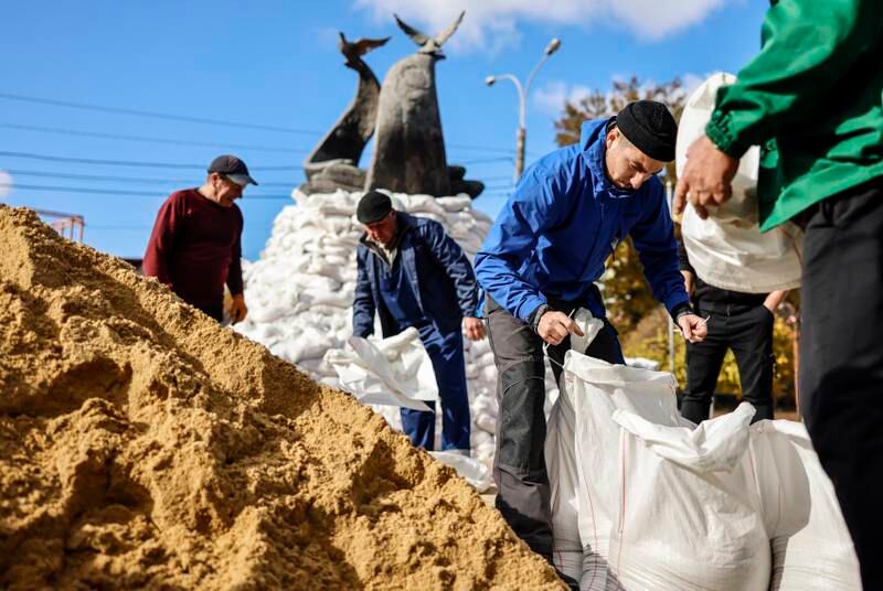 Workers surround the Monument to the Heroes of the Heavenly Hundred with sandbags against damage from shelling in Mykolaiv. EPA