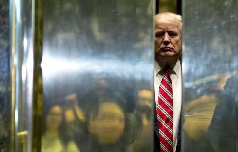 AFP presents a retrospective photo package of 60 pictures marking the 4-year presidency of President Trump.

US President-elect Donald Trump boards the elevator after escorting Martin Luther King III to the lobby after meetings at Trump Tower in New York City on January 16, 2017.   - 
 / AFP / DOMINICK REUTER
