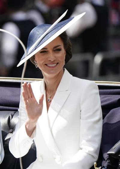 The Duchess of Cambridge wears a white dress coat, thought to be Alexander McQueen, with a black and white Philip Treacy hat and a pair of sapphire earrings for Trooping the Colour. PA 