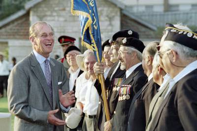 Prince Philip, Duke of Edinburgh, bursts out in laughter during a conversation with WW II veterans after a wreath-laying ceremony at the main Commonwealth War Graves Cemetery in Ramle on October 30, 1994. The Prince is in Israel for a 24-hour visit.  AFP PHOTO SVEN NACKSTRAND (Photo by SVEN NACKSTRAND / AFP)