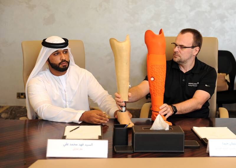 Fahad Ali (L), a long-term amputee, compares conventional examples with his new 3D-printed prosthetics alongside Sebastian Giede, a certified orthopaedic prosthetist with Mediclinic. Photo: Dubai Health Authority