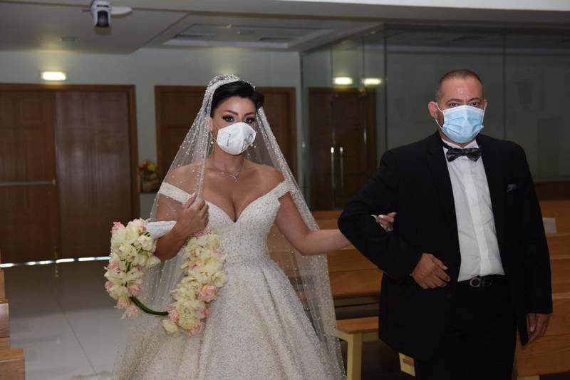 Laura Daher walks down the aisle with her brother George. The pandemic meant there was a limit on how many people could attend her wedding. Laura Daher and Elie Abi Daher