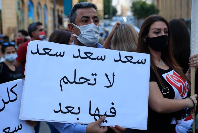 An anti-government protester holds an Arabic placard that reads: "Saad don't dream on it any more," during a protest to denounce the naming of former Prime minister Saad Hariri as a potential candidate as the country's new prime minister, in downtown Beirut. AP Photo