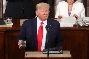 President Donald Trump holds a glass of water during the State of the Union address. Getty Images / AFP