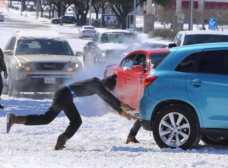 People push a car free after spinning out in the snow in Waco, Texas. A winter storm that brought snow and ice across the southern Plains stretched its frigid fingers down to the Gulf Coast. AP