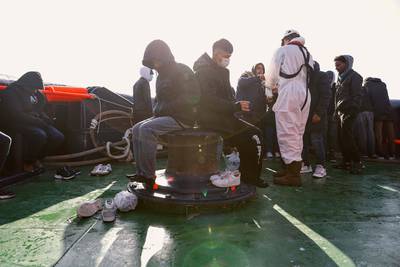 Migrants sit on board the 'Abeille Languedoc' after being rescued. 