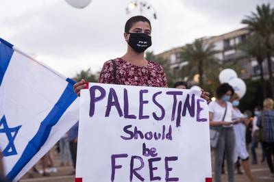 TEL AVIV, ISRAEL - JUNE 23: An Israeli woman holds a sign that reads "Palestine should be free" as she protest against Israel goverment's plan to annex parts of the West Bank in Tel Aviv, Israel. Getty Images