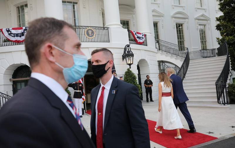 US Secret Service agents wear protective face masks due to the  pandemic as US President Donald Trump and first lady Melania Trump walk back into the South Portico of the White House after hosting a 4th of July "2020 Salute to America" on the South Lawn of the White House in Washington, US, July 4. Carlos Barria / Reuters
