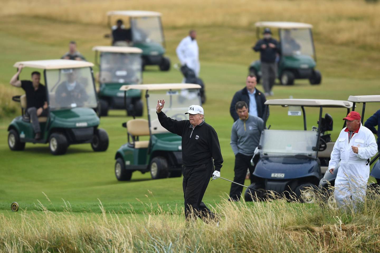 TURNBERRY, SCOTLAND - JULY 15:  U.S. President Donald Trump waves whilst playing a round of golf at Trump Turnberry Luxury Collection Resort during the U.S. President's first official visit to the United Kingdom on July 15, 2018 in Turnberry, Scotland. The President of the United States and First Lady, Melania Trump on their first official visit to the UK after yesterday's meetings with the Prime Minister and the Queen is in Scotland for private weekend stay at his Turnberry.  (Photo by Leon Neal/Getty Images) ***BESTPIX***