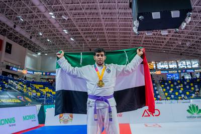 Hazza Farhan draped in the UAE flag celebrates his gold medal. Photo: UAEJJF