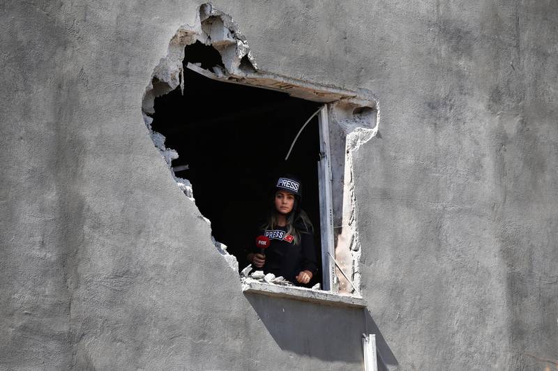 A journalist looks out of an hole on a house that was damaged by a mortar fired from inside Syria, on the Turkish town of Akcakale, southeaster, Turkey.Nobody got hurt by the attack. The owners of the house weren't home at the time of the attack. Turkey says its military offensive has taken central Ras al-Ayn, a key border town in northeastern Syria, and its most significant gain since its cross-border operation began against Syrian Kurdish fighters began. AP Photo