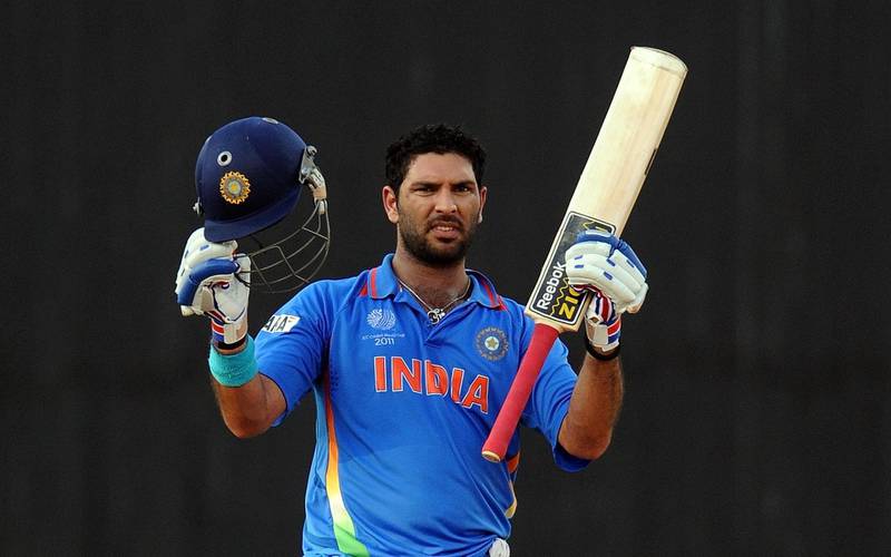 India batsman Yuvraj Singh raises his bat and helmet after his century (100 runs) during the Cricket World Cup match between India and West Indies at the M. A. Chidambaram Stadium in Chennai on March 20, 2011. AFP PHOTO / Prakash SINGH (Photo by PRAKASH SINGH / AFP)