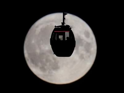 People view the blue supermoon as they travel in a Cloud Cable Car in London.  AP
