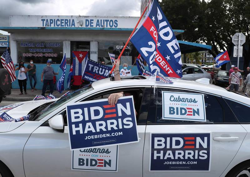 A caravan of supporters for Democratic presidential nominee Joe Biden drive past supporters of President Donald Trump standing on the sidewalk next to the Versailles Restaurant during a Worker Caravan for Biden event  in Miami, Florida. AFP