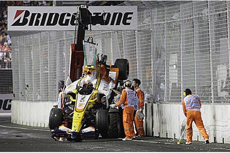 Track marshals recover the crashed Renault car of Nelson Piquet Jr during the 2008 Singapore Grand Prix.