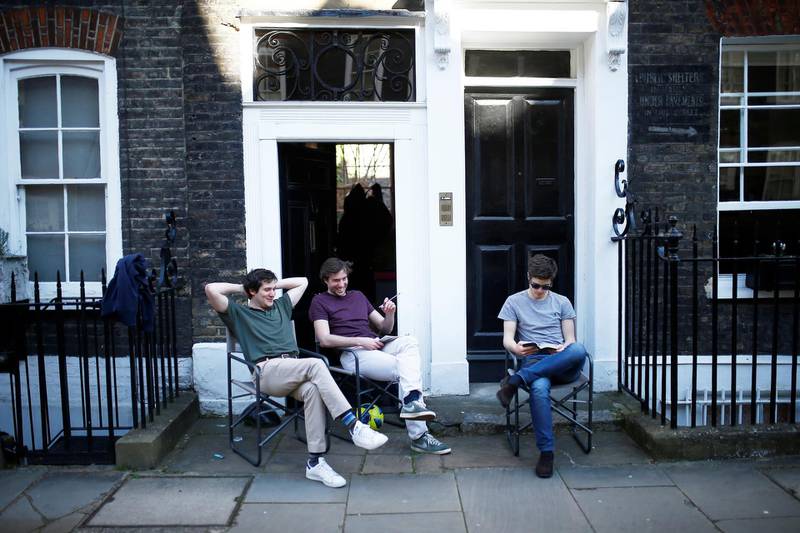 People sit in front of their home in Westminster, as the spread of the coronavirus continues, in London, UK on April 5, 2020. Reuters
