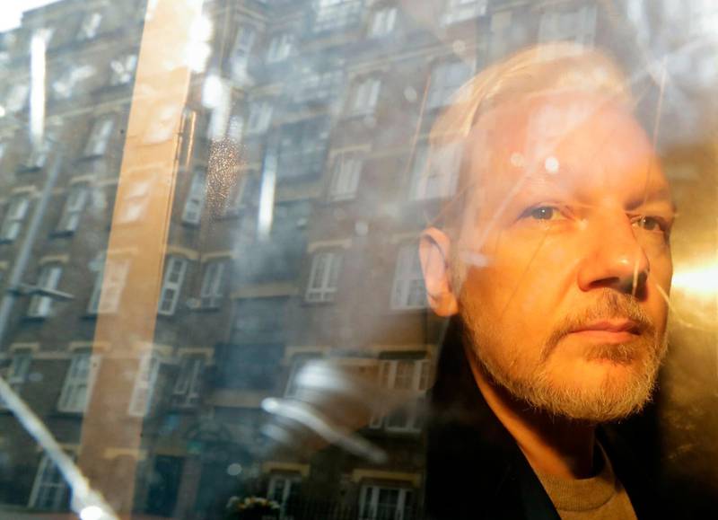 FILE - In this Wednesday May 1, 2019 file photo buildings are reflected in the window as WikiLeaks founder Julian Assange is taken from court, where he appeared on charges of jumping British bail seven years ago, in London. WikiLeaks founder Julian Assange will find out Monday Jan. 4, 2021 whether he can be extradited from the U.K. to the U.S. to face espionage charges over the publication of secret American military documents. (AP Photo/Matt Dunham, File)