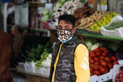 A vendor wears a protective face mask following the coronavirus outbreak, at a local vegetables and fruits market in Sanabis west of Manama, Bahrain. Reuters